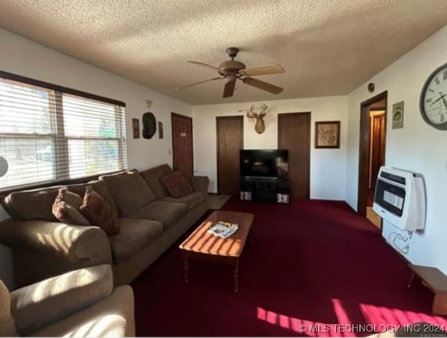 living room with a textured ceiling, heating unit, ceiling fan, and carpet floors