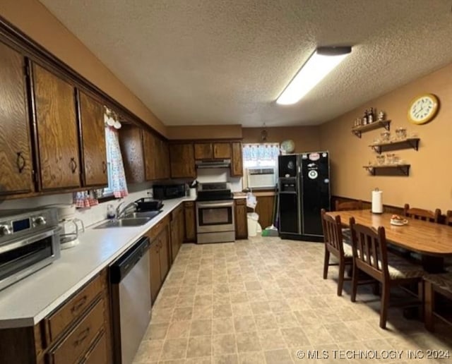 kitchen with dark brown cabinetry, sink, black appliances, and a textured ceiling