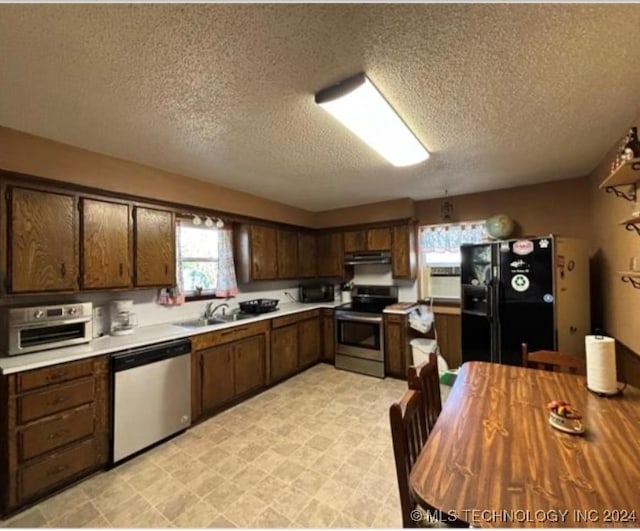 kitchen with sink, a textured ceiling, dark brown cabinetry, and black appliances