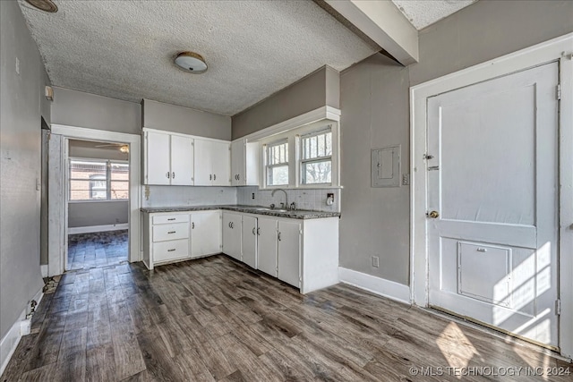 kitchen with a textured ceiling, white cabinetry, sink, and dark hardwood / wood-style flooring