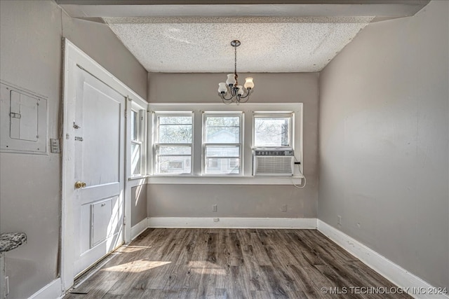 interior space with cooling unit, electric panel, a textured ceiling, dark wood-type flooring, and a notable chandelier