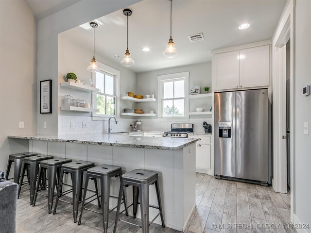 86 Ridgeline, Carlton Landing, OK 74432 - kitchen with open shelves, a sink, stainless steel appliances, white cabinets, and a peninsula