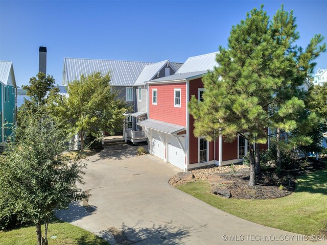 86 Ridgeline, Carlton Landing, OK 74432 - view of side of home featuring concrete driveway, metal roof, and a garage