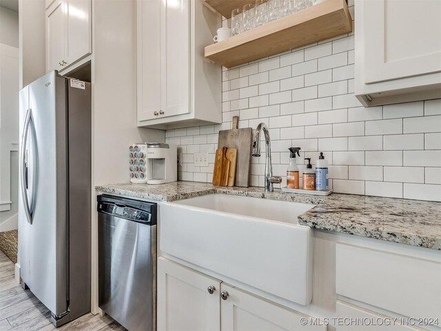 86 Ridgeline, Carlton Landing, OK 74432 - kitchen featuring white cabinetry, a sink, backsplash, and appliances with stainless steel finishes