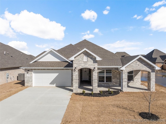2804 E Northampton St, Broken Arrow, OK 74014 - french country home with cooling unit, brick siding, an attached garage, and driveway