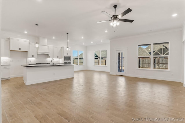 2804 E Northampton St, Broken Arrow, OK 74014 - unfurnished living room featuring healthy amount of natural light, crown molding, a ceiling fan, recessed lighting, and a sink
