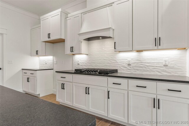2804 E Northampton St, Broken Arrow, OK 74014 - kitchen with gas cooktop, custom exhaust hood, light wood finished floors, decorative backsplash, and crown molding