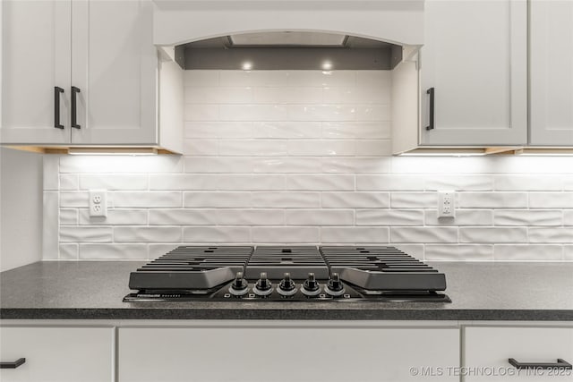 2804 E Northampton St, Broken Arrow, OK 74014 - kitchen with black stovetop, arched walkways, dark countertops, and decorative backsplash