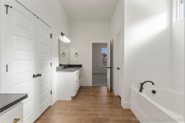 2804 E Northampton St, Broken Arrow, OK 74014 - full bath featuring vanity, a garden tub, wood finish floors, and baseboards