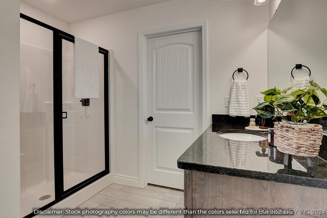 bathroom with vanity, tile patterned flooring, and a shower with door