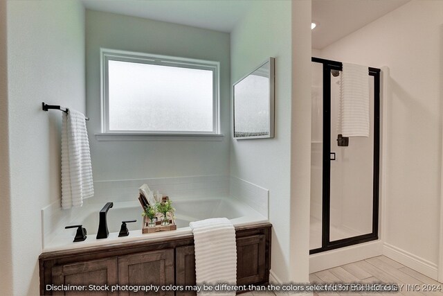 bathroom featuring hardwood / wood-style flooring and separate shower and tub