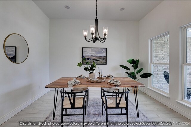 dining space featuring a notable chandelier, light wood-type flooring, and a wealth of natural light