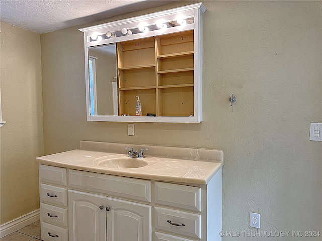 bathroom featuring a textured ceiling, tile patterned flooring, and vanity