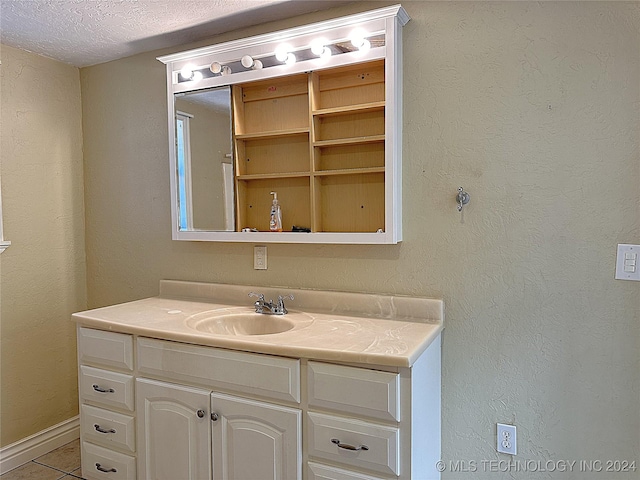 bathroom featuring a textured ceiling, vanity, and tile patterned flooring