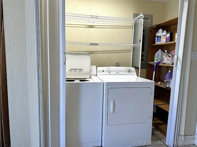 washroom featuring laundry area, washer and clothes dryer, and a textured wall
