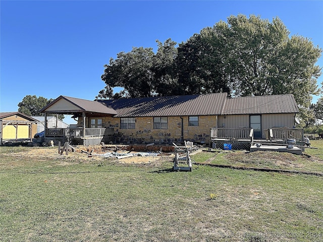 back of house with metal roof, a deck, a yard, and a gazebo