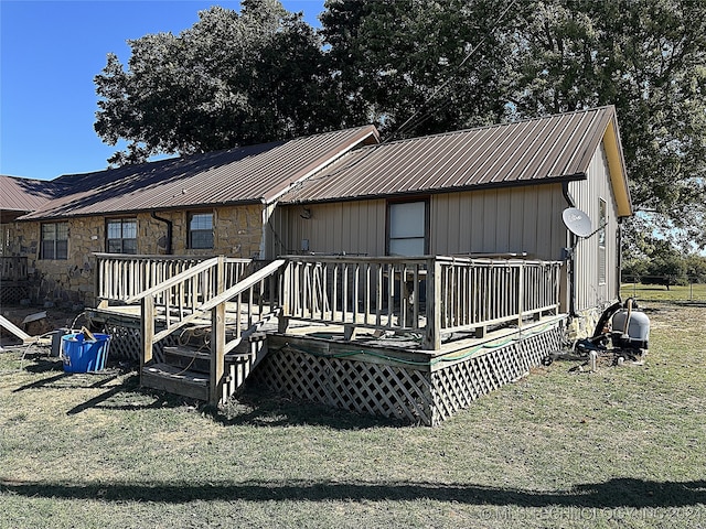 back of property featuring a deck and a yard