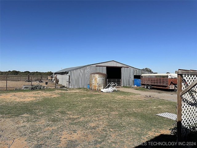 view of yard featuring fence, an outdoor structure, and an outbuilding