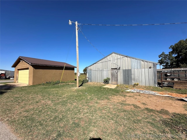 view of yard with a detached garage and an outbuilding