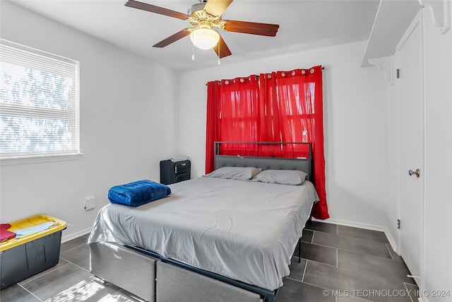 tiled bedroom featuring ceiling fan