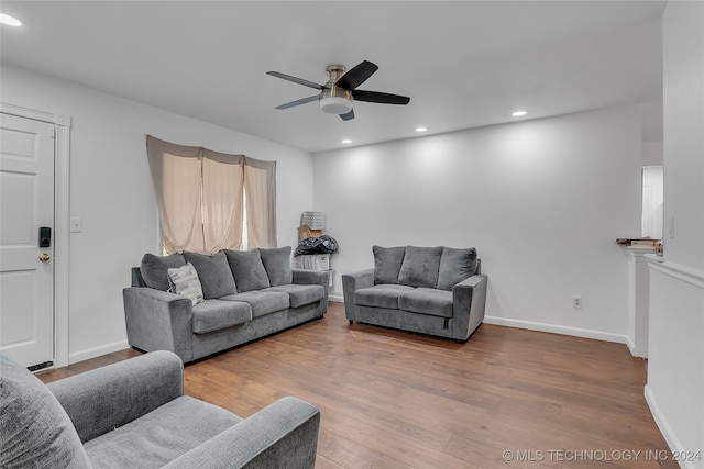 living room featuring hardwood / wood-style floors and ceiling fan