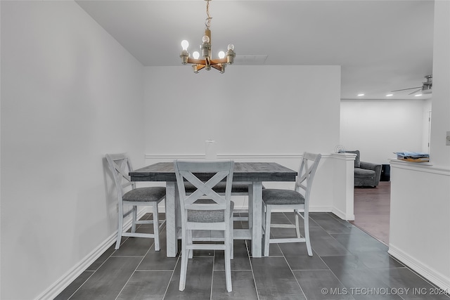 dining space featuring ceiling fan with notable chandelier