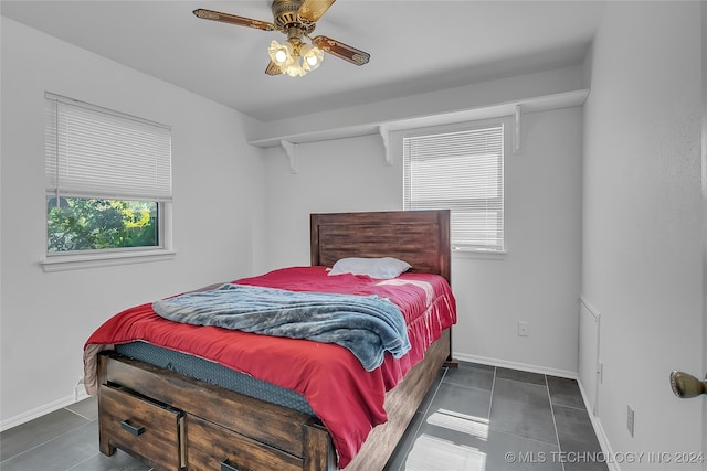 bedroom with dark tile patterned floors and ceiling fan