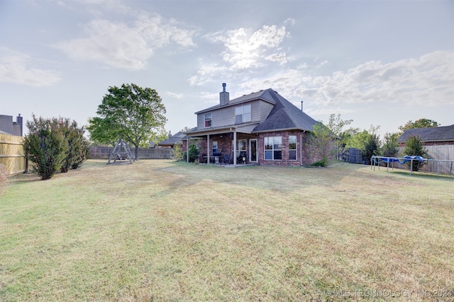 rear view of property with a lawn and a patio