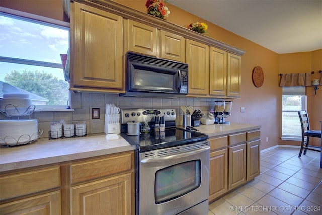 kitchen with backsplash, light tile patterned flooring, and stainless steel range with electric cooktop