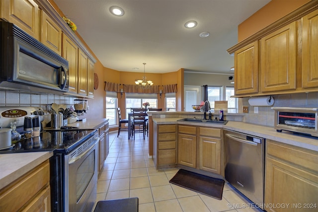 kitchen featuring tasteful backsplash, stainless steel appliances, decorative light fixtures, a notable chandelier, and sink