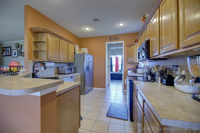 kitchen with kitchen peninsula, decorative backsplash, sink, light tile patterned floors, and appliances with stainless steel finishes