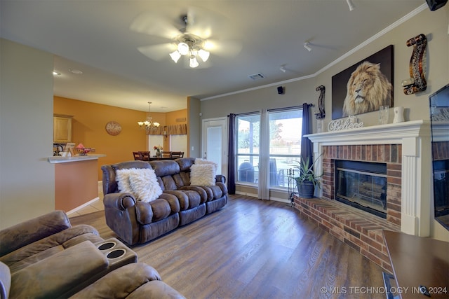 living room with dark hardwood / wood-style flooring, ceiling fan with notable chandelier, crown molding, and a fireplace