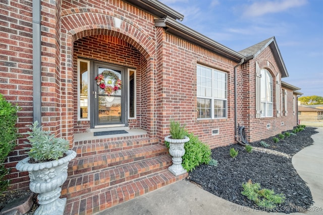 view of exterior entry with brick siding