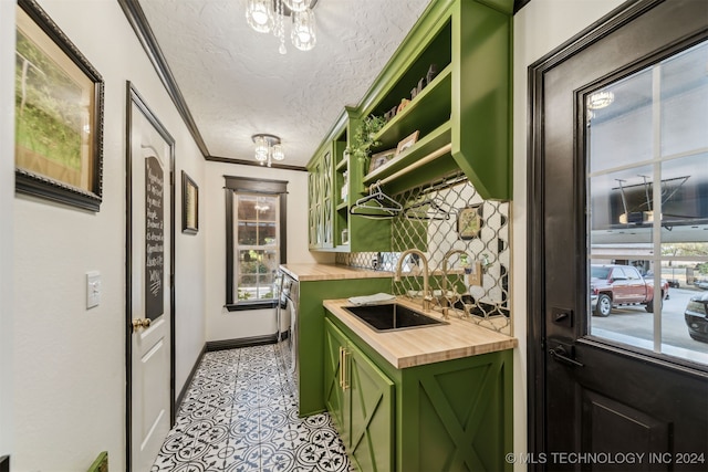 kitchen featuring open shelves, a sink, a textured ceiling, butcher block counters, and green cabinetry