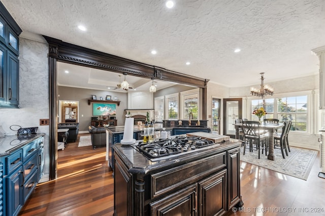 kitchen with dark wood-style floors, stainless steel gas cooktop, blue cabinets, and ornamental molding