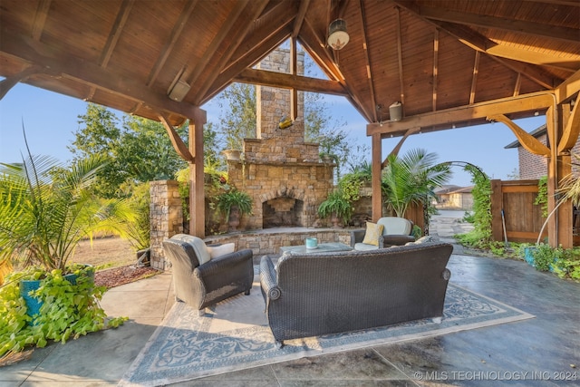 view of patio / terrace with a gazebo, an outdoor living space with a fireplace, and fence