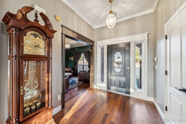 foyer entrance with crown molding, baseboards, and wood finished floors