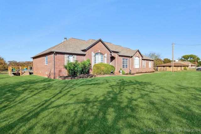 view of front of home featuring a front lawn, brick siding, and a shingled roof