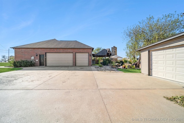 view of property exterior featuring a garage, brick siding, and concrete driveway