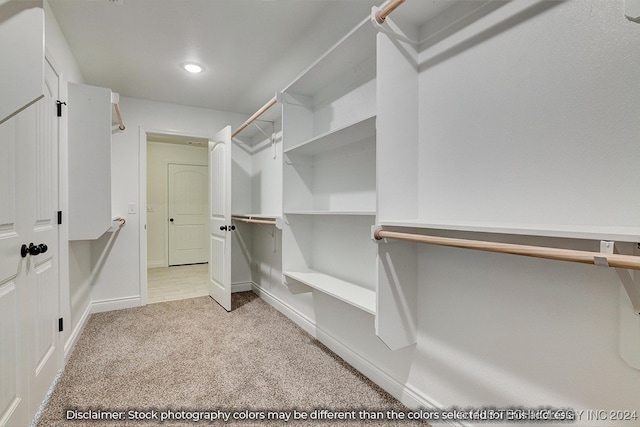 walk in closet featuring light colored carpet