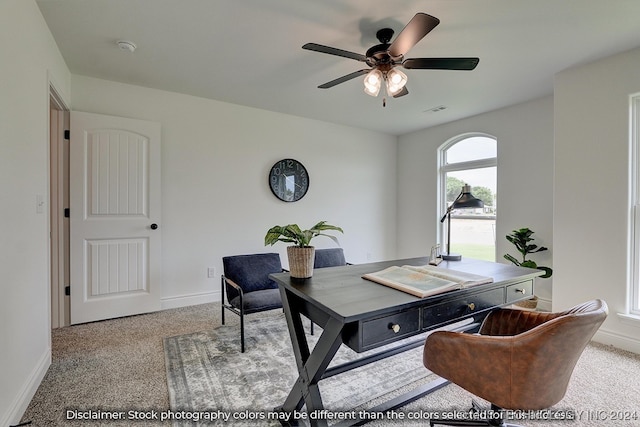 carpeted home office featuring ceiling fan