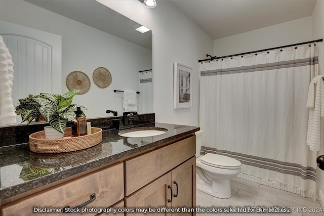 bathroom with tile patterned flooring, toilet, walk in shower, and vanity