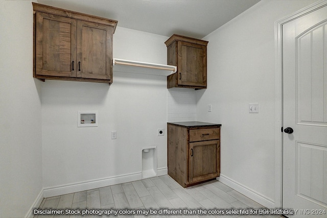 clothes washing area with light wood-type flooring, hookup for a washing machine, cabinets, and electric dryer hookup