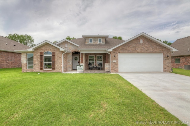 craftsman inspired home with a garage, cooling unit, and a front yard