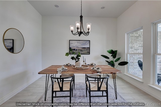 dining space featuring light hardwood / wood-style floors, a healthy amount of sunlight, and an inviting chandelier