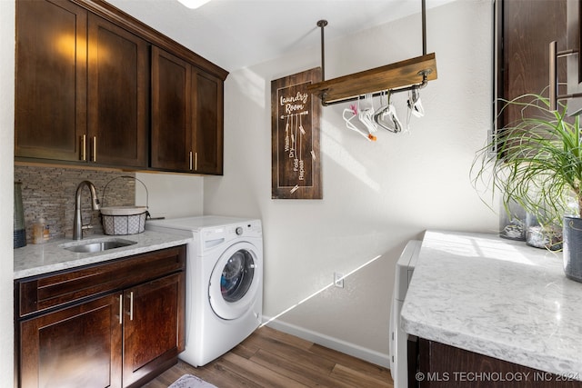 laundry area featuring cabinets, hardwood / wood-style floors, sink, and washer / dryer