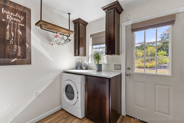 laundry area with cabinets, light wood-type flooring, and washer / dryer