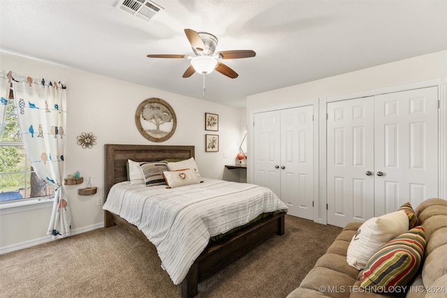 bedroom featuring two closets, carpet flooring, and ceiling fan