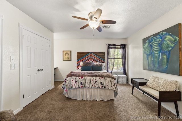 bedroom with ceiling fan, carpet floors, and a textured ceiling