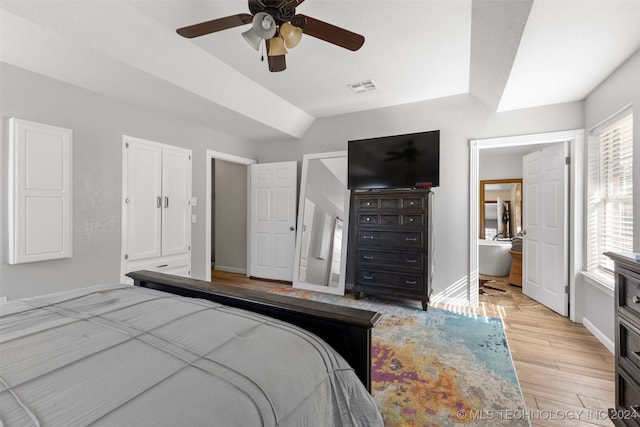 bedroom featuring lofted ceiling, ensuite bath, ceiling fan, and light hardwood / wood-style floors